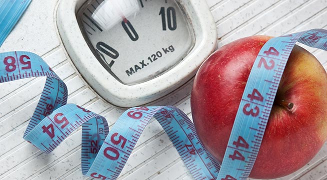 Lose weight Scales, measuring tape and an apple